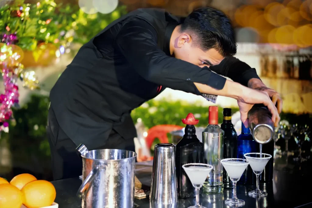 A bartender preparing cocktails for the guests.