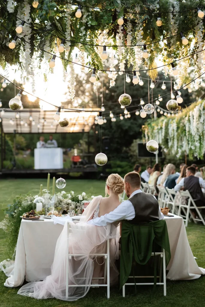 A picture of a garden wedding, filled with flowers and fairy lights.