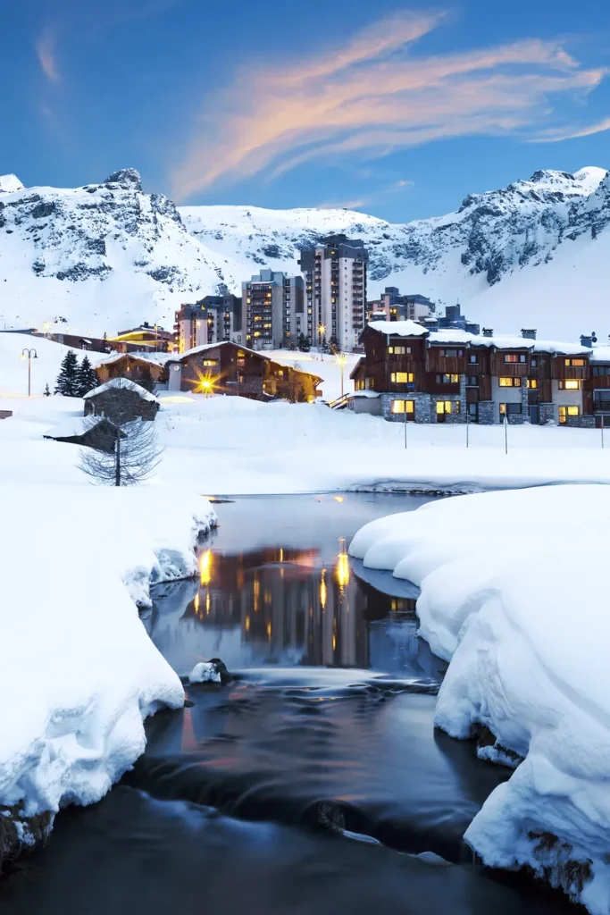 A picture of a ski lodge with mountains behind it.