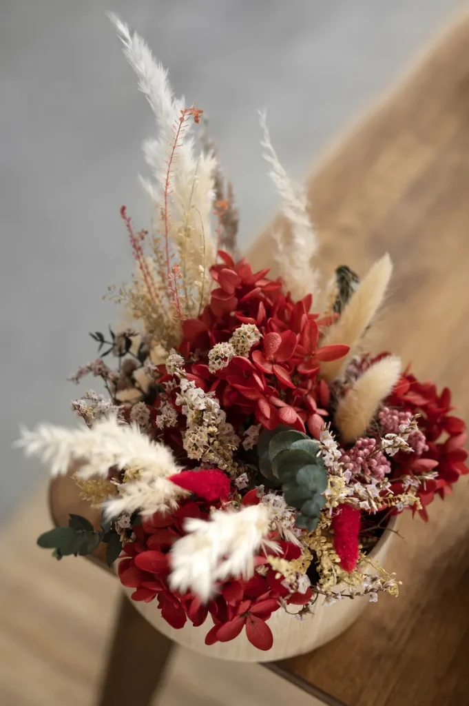 A rustic red wedding bouquet with dried florals.