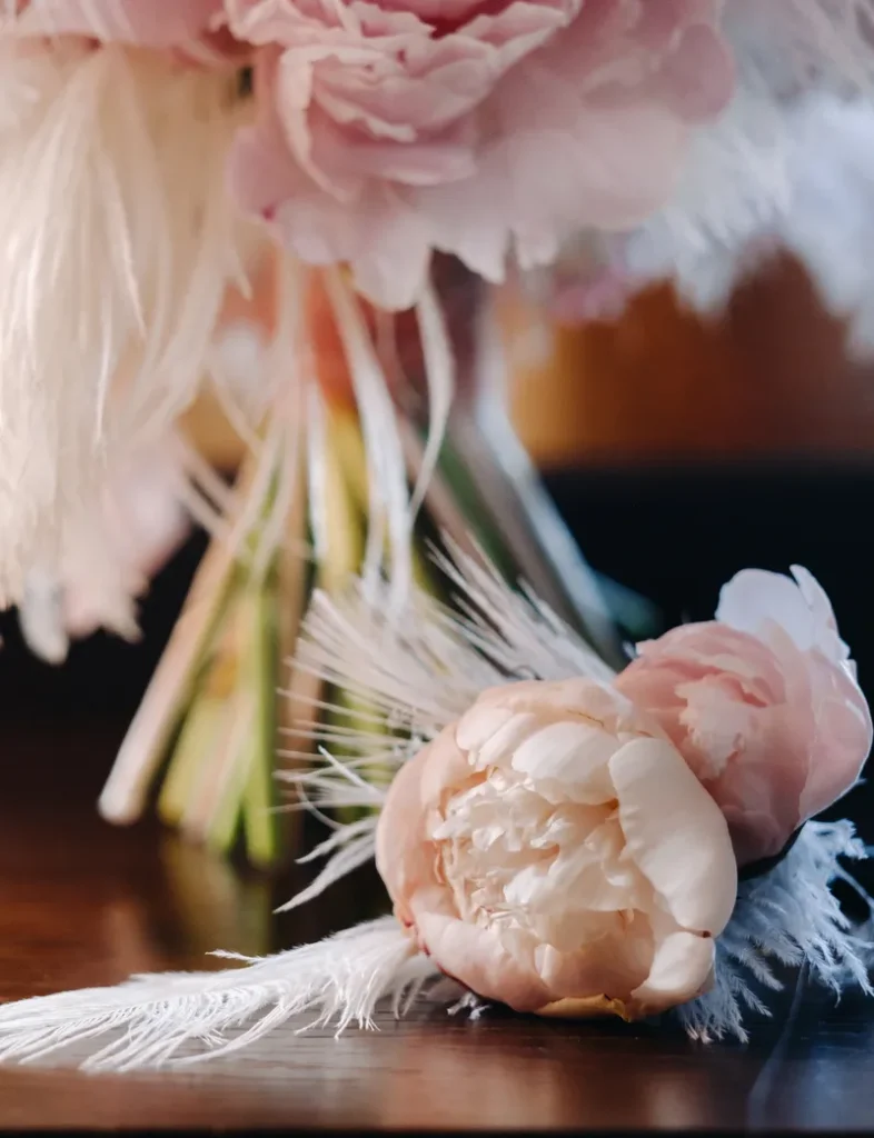 A beautiful floral bouquet with some fluffy white feathers as accents.