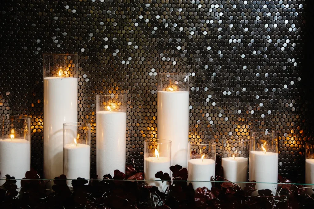 A bunch of candles in front of a sparkly background.