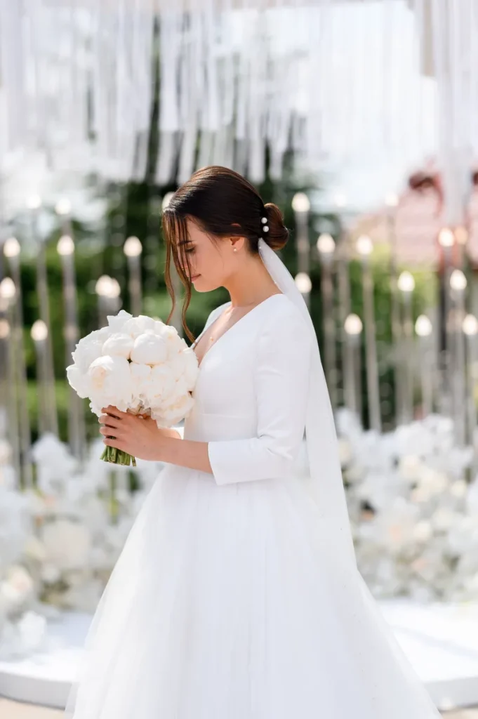 A picture of a bride in white, with beautiful white decor.